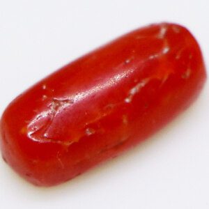 Close-up of a sparkling 3-carat coral loose stone on a white background.