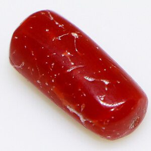 Close-up of a sparkling red orange coral loose stone on a white background.