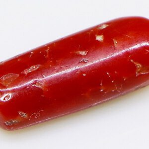 Red probal loose stone surrounded by other gemstones, highlighting its versatility in jewelry design.