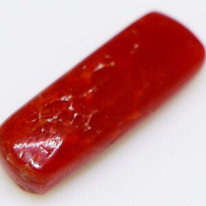 Macro shot of a red probal loose gemstone, revealing its unique internal characteristics.