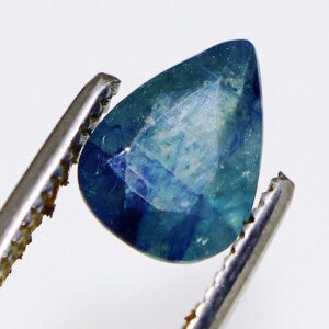 The Sapphire Shop loose gemstone held in tweezers.