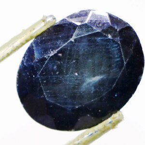 Close-up of big sapphire loose gemstone with tweezers