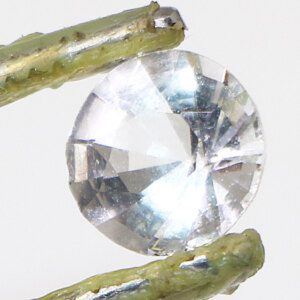 Safed Topaz gemstone held by tweezers for quality inspection