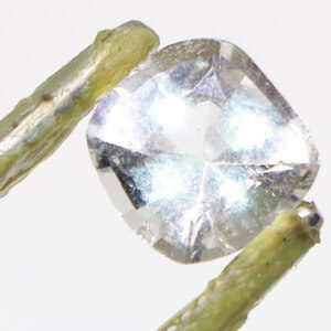 Topaz gemstone held by tweezers for quality inspection