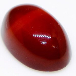 Close-up of a polished agate gemstone held in tweezers, showcasing its vibrant color and high shine.