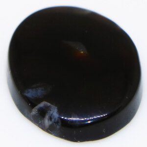 Closeup photo of a Black Agate loose gemstone held in tweezers, showcasing its deep black color.