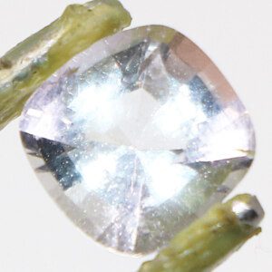 Ceylon Oval White Topaz gemstone held by tweezers